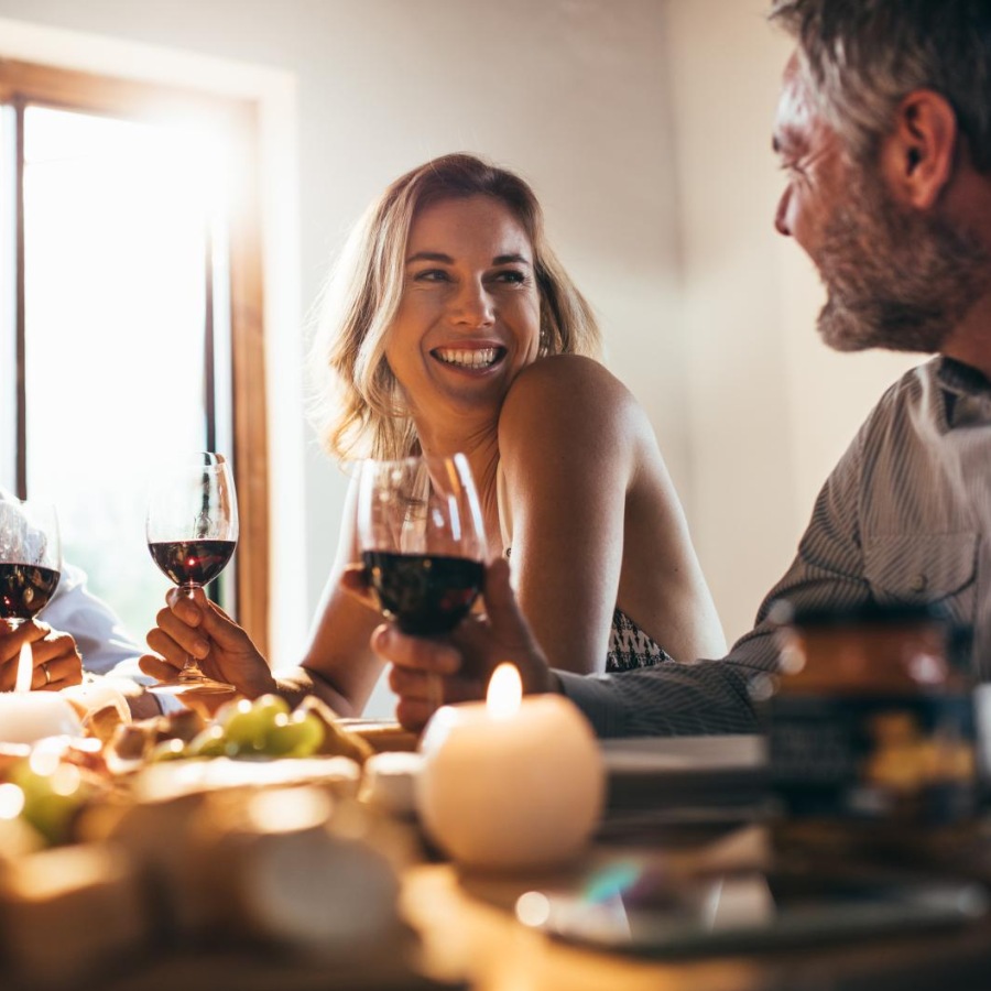 a group of people sitting at a table with food and drinks